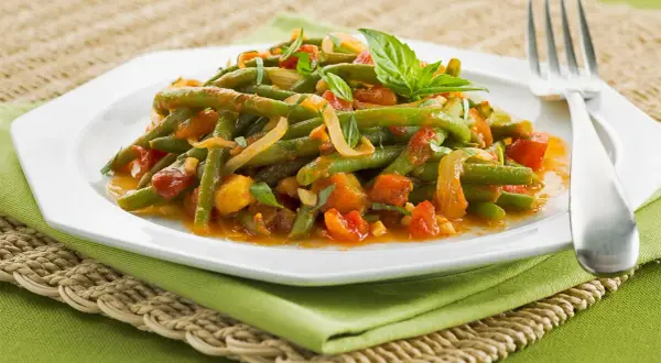Haricots verts à l'italienne, tendres et savoureux, mijotés avec des tomates et des herbes fraîches.