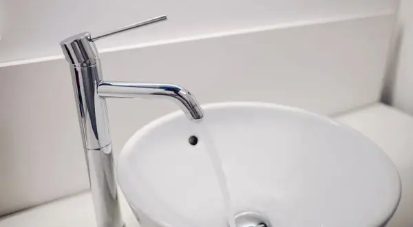 Grifo moderno y lavabo blanco. ¿Buscas el precio reforma baño 4 m2?