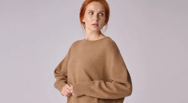 Kobieta w brązowym swetrze z wełny wielbłądziej.