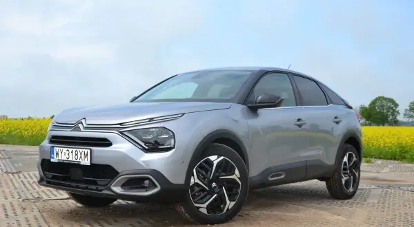 Srebrny Citroën C4 na tle kwitnącego pola rzepaku. Stylowy design i nowoczesne linie tego c4 zachwycają.