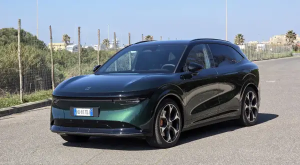 Zeekr 7x, un SUV elettrico dal design futuristico, parcheggiato su strada asfaltata con vegetazione e palme sullo sfondo.