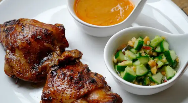 Krispigt, glansigt sticky chicken serveras med en krämig sås och en fräsch gurksallad.