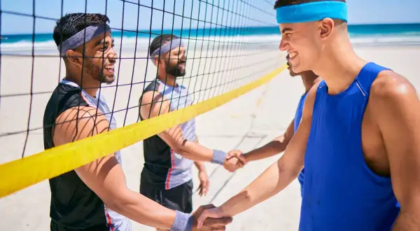 Uściski dłoni po zaciętej grze na mistrzostwach w siatkówce plażowej.