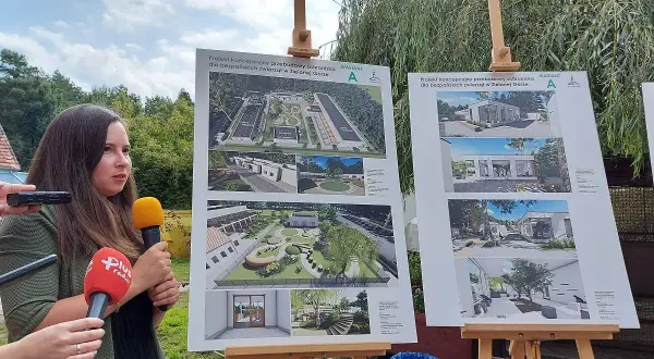 Kobieta z mikrofonami prezentuje projekty architektoniczne schroniska dla zwierząt w Zielonej Górze.