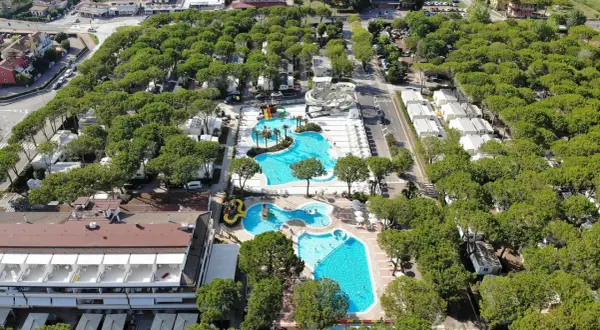 Malowniczy camping residence village z basenami, zjeżdżalniami i domkami wśród drzew. Idealne miejsce na wakacje.
