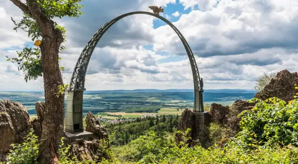 Ein imposanter Bogen mit Adlerkrone thront über einer malerischen Landschaft. Ein tolles Motiv für Ausflugsziele Rheinland-Pfalz.