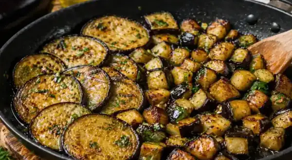 Aubergines coupées en rondelles et en dés, poêlées avec des herbes. Une délicieuse recette aubergine poêle prête à être dégustée.