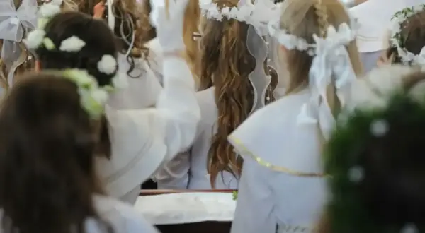 Dzieci w bieli, z wiankami na głowach, czekają na komunię. Zastanawiasz się, ile daje się na komunię?