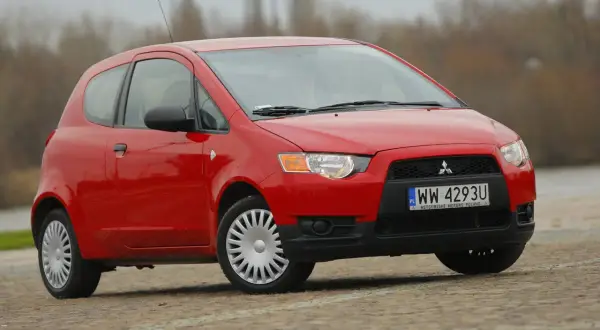 Czerwony Mitsubishi Colt na zewnątrz. Poznaj jego kompaktowe mitsubishi colt wymiary, idealne do miasta.