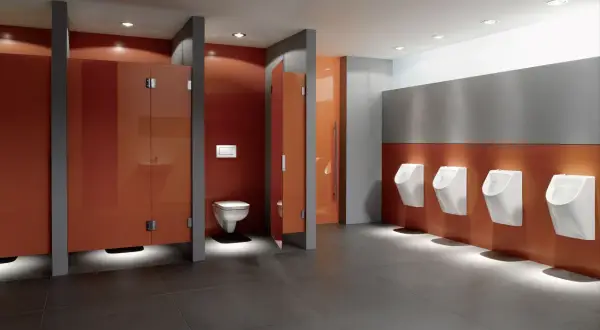 Moderne schul toilette mit orangen Kabinen und Reihen von Urinalen.