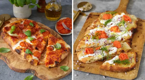 Två pizzor på träskärbrädor. En med pepperoni och basilika, den andra med gräddfil, rödlök, dill och rom. Båda ser ut att ha en härlig pizza sås.