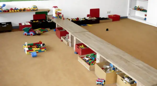 Spielzeugkisten und Bausteine im Kita-Raum laden zu kreativen Ideen ein.