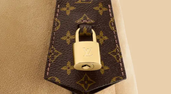 Złota kłódka z logo LV na brązowej skórze z monogramem Louis Vuitton.