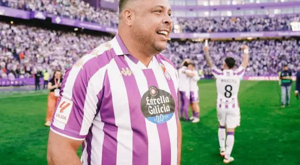 Ronaldo w koszulce Real Valladolid świętuje na boisku. Tłumy kibiców na trybunach.