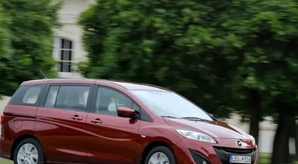 Czerwona Mazda 5 w ruchu, zgrabna i przestronna, idealna na rodzinne wycieczki. Poznaj jej mazda 5 wymiary.