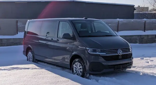 Szary bus Volkswagen w śniegu.