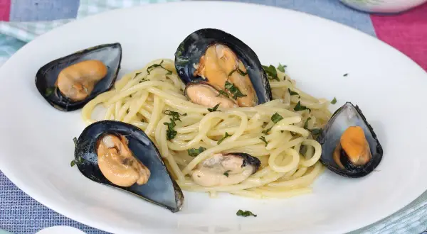 Spaghetti con le cozze in bianco, un piatto semplice e gustoso, con cozze fresche e prezzemolo tritato.
