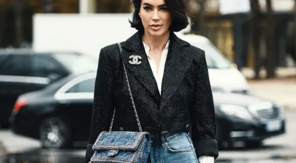 Elegancka kobieta w tweedowej marynarce i jeansach, z torebką Chanel. Klasyczne coco chanel stylizacje.
