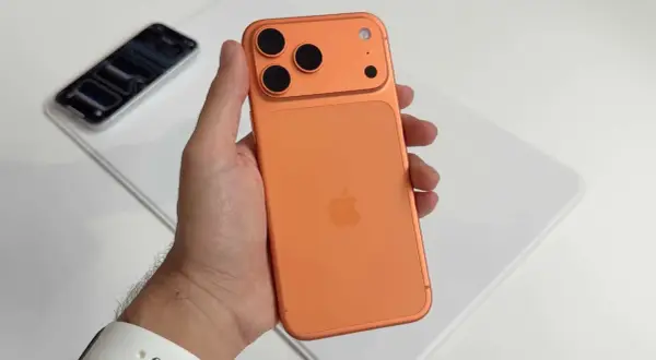 Maintenant, un **iphone avec 4 caméras** orange est tenu dans une main.