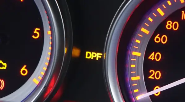 Świecąca żółta kontrolka DPF na desce rozdzielczej samochodu.