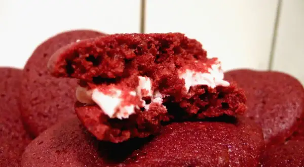 En närbild på en delad red velvet kaka med krämig fyllning.