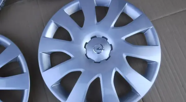Srebrne kołpaki Opel Vivaro z logo marki. Komplet czterech sztuk, idealny do odświeżenia wyglądu Twojego auta.