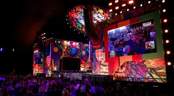 Kolorowa scena festiwalu Pol'and'Rock z wielkim ekranem wyświetlającym tłum i artystów.