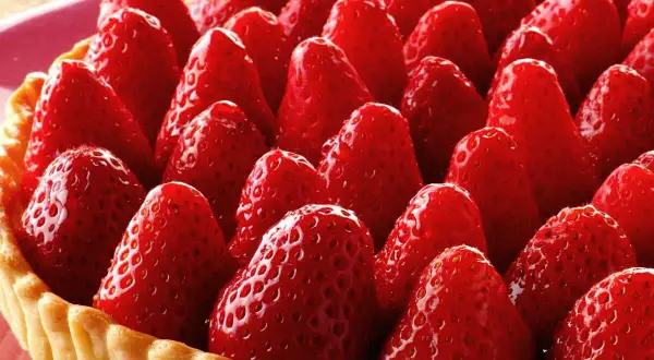 Tarte aux fraises sans crème pâtissière, une explosion de fruits rouges sur une pâte dorée. Un délice simple et fruité.