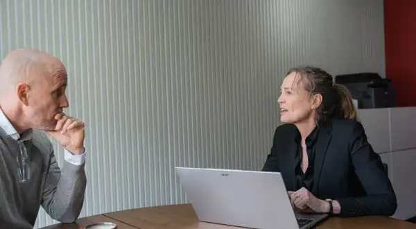 Man en vrouw in gesprek, oefenen gesprekstechnieken lastige mensen. De man denkt na, de vrouw legt uit.