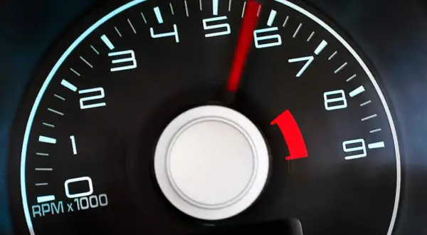 Tacómetro de un coche diésel mostrando altas revoluciones. La aguja roja apunta entre 5 y 6, indicando un motor acelerado.