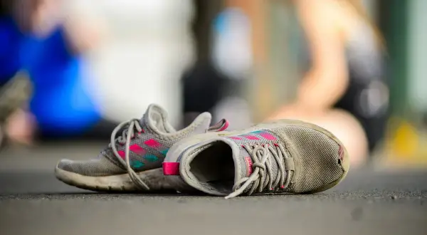 Zniszczone buty sportowe, z dziurą w jednym z nich. Zastanawiasz się, jak załatać dziurę w bucie, by znów móc biegać?