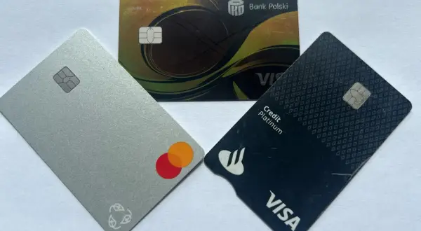 Trzy karty płatnicze: srebrna z logo Mastercard, czarna z logo Visa Credit Platinum i złota z logo Banku Polskiego.