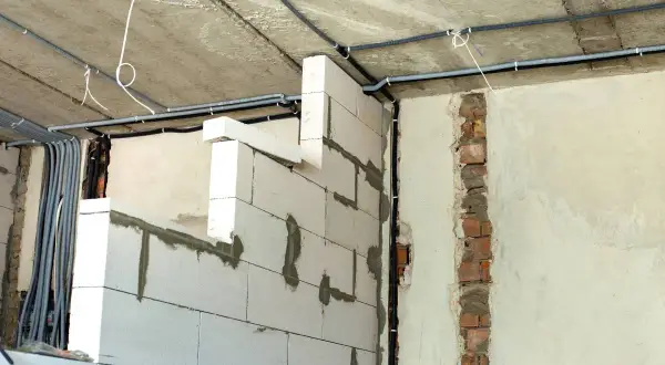 Ścianki działowe na poddaszu z bloczków gazobetonowych, z widocznym układem instalacji elektrycznej. Widać, jak wysoko murować ścianki działowe na poddaszu, by zapewnić miejsce na przewody.