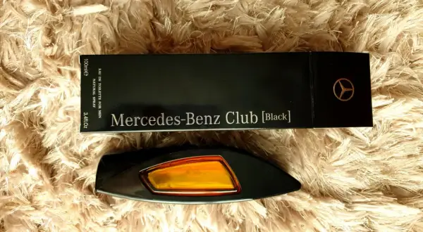 Elegancki flakon perfum Mercedes-Benz Club [Black] na puszystym tle.