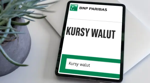 Tablet z aplikacją BNP Paribas wyświetla "Kursy walut". Obok stoi doniczka z rośliną.