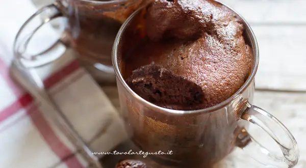 Due mug cake al cioccolato, soffici e golosi, serviti in tazze di vetro. Perfetti per una pausa dolce.