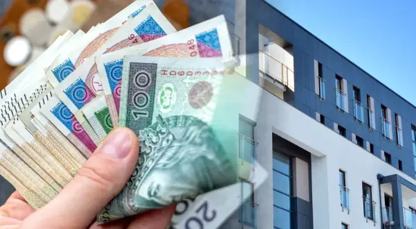 Dłoń trzyma polskie banknoty, symbolizujące kredyt na wkład własny na zakup nowoczesnego mieszkania.