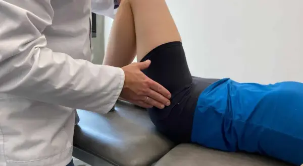 Fizjoterapeuta bada biodra, oceniając zakres ruchu i potencjalne hip dips.