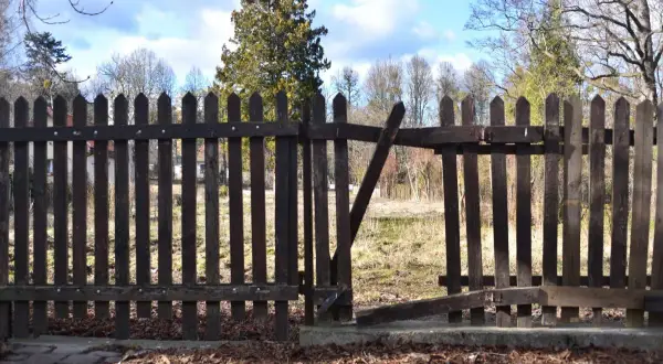 Drewniane ogrodzenie między sąsiadami, z otwartą furtką. Czy przepisy pozwalają na takie rozwiązania?
