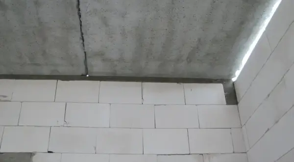 Betonowy strop dz 3 z widocznym pęknięciem, nad ścianą z białych pustaków.