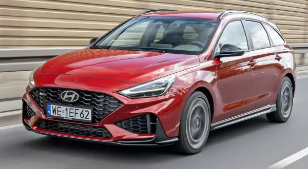 Czerwony Hyundai i30 N Line kombi w ruchu drogowym. Sportowy wygląd i dynamiczna jazda.