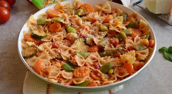 Pyszny makaron z warzywami na patelnię: farfalle z cukinią, marchewką i papryką w sosie pomidorowym.
