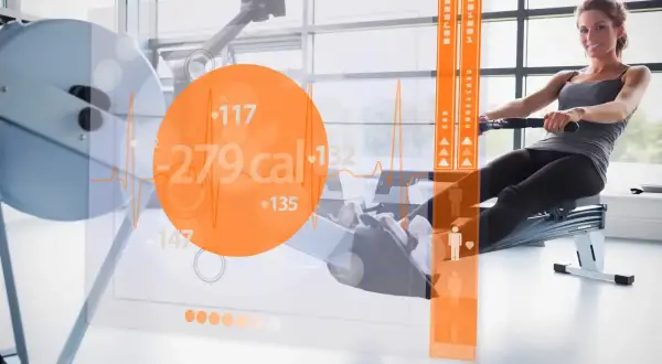Frau rudert auf einem Ergometer, während eine Anzeige den hohen Kalorienverbrauch von 279 kcal zeigt.