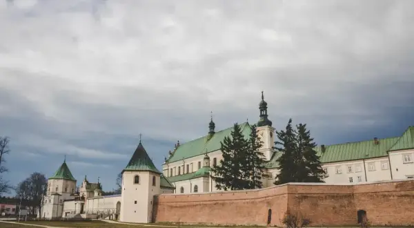 Bazylika w Leżajsku, jedna z głównych atrakcji, z zielonymi dachami i ceglanym murem obronnym.