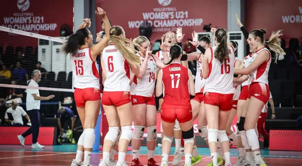 Drużyna siatkówki kobiet u21 świętuje zwycięstwo na Mistrzostwach Świata. Radość i entuzjazm po wygranej.