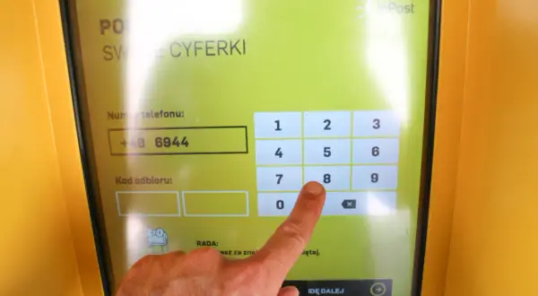 Palec wskazujący naciska cyfrę 8 na ekranie paczkomatu InPost.
