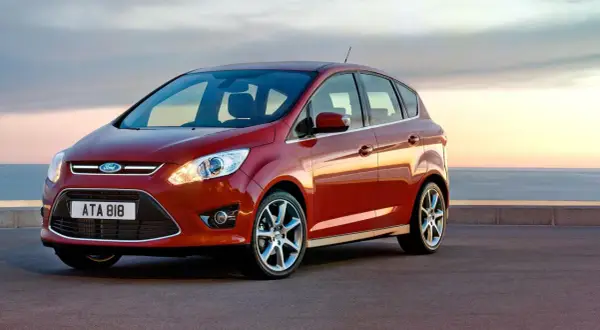 Röd Ford C-Max parkerad vid havet. Inga problem här, bara en vacker vy.