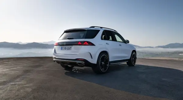 Biały Mercedes GLE 2026 z czarnymi felgami na tle górskiego krajobrazu.