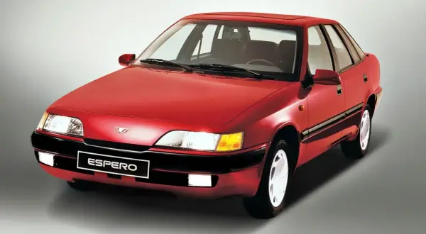 Czerwony Daewoo Espero z lat 90. na szarym tle. Klasyczny sedan, który wciąż budzi nostalgię.