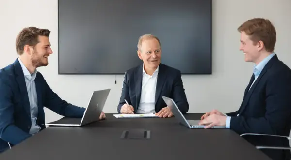 Fabian Bengtsson och kollegor i möte med laptops och anteckningsblock.